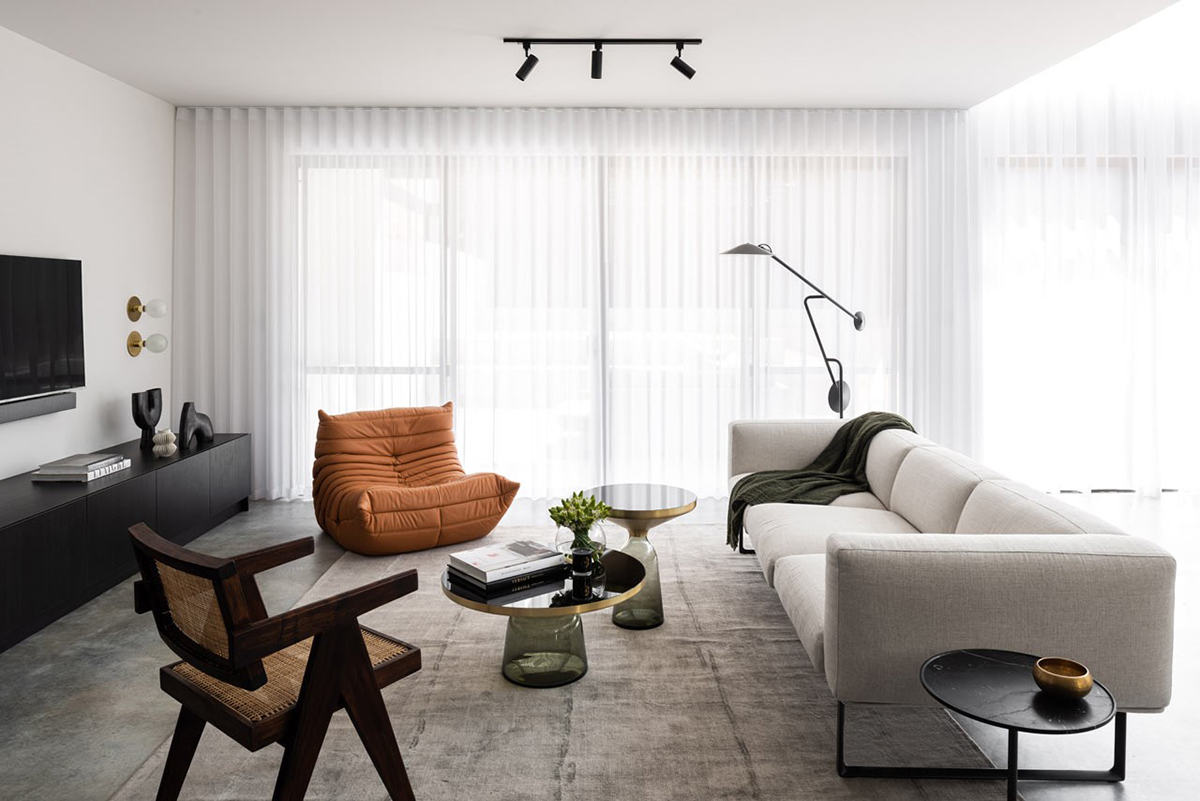 KBS apartment – Nickolas Gurtler interior design. Chiếc ghế màu cam ngói là điểm nhấn cho phòng khách.